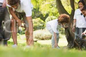 Team of volunteers picking up litter in park