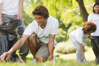 Team of volunteers picking up litter in park