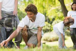 Team of volunteers picking up litter in park