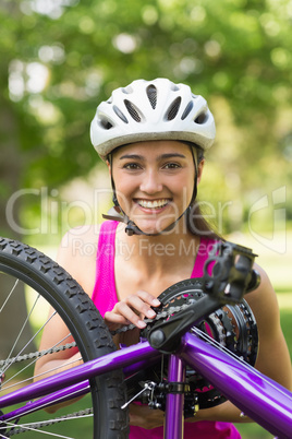 Happy young woman wearing helmet with bicycle