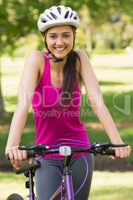 Fit young woman with helmet riding bicycle