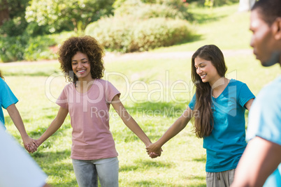 Friends holding hands in circle at park