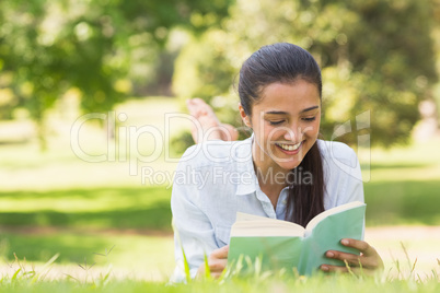 Smiling woman reading a book in park