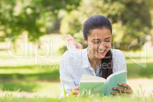 Smiling woman reading a book in park