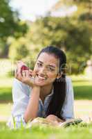 Smiling young woman reading a book in park