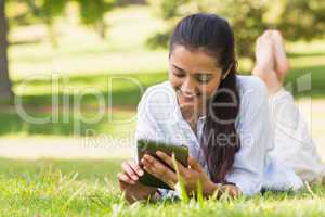 Woman text messaging while relaxing in park