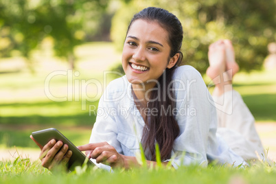 Woman text messaging while relaxing in park