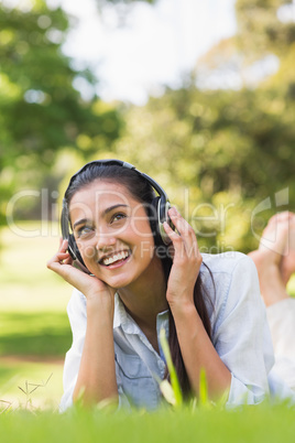 Cheerful young woman enjoying music in park