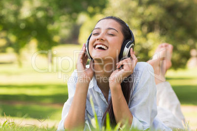 Cheerful young woman enjoying music in park