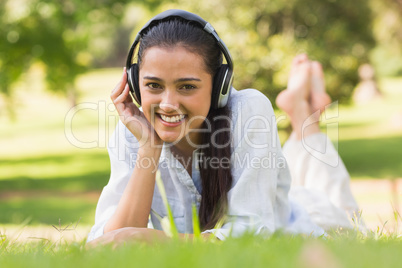 Cheerful young woman enjoying music in park