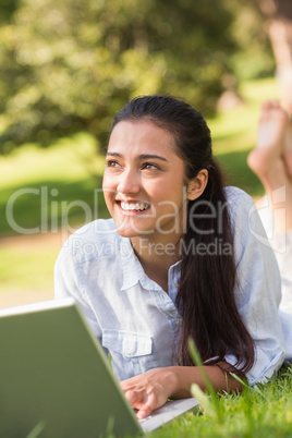 Smiling young woman using laptop in park