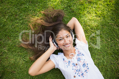 Cheerful young woman enjoying music in park