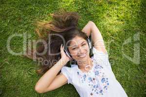 Cheerful young woman enjoying music in park