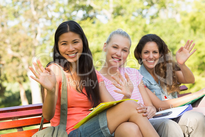 Female college friends sitting on campus bench