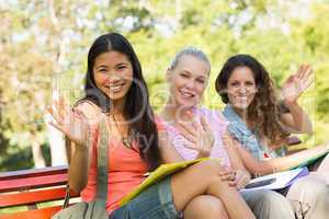 Female college friends sitting on campus bench
