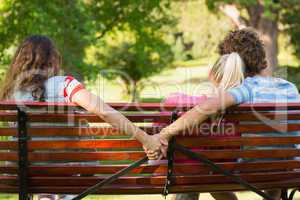 Man with girlfriend while holding hands with another woman