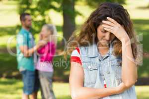 Angry woman with man and girlfriend in background at park