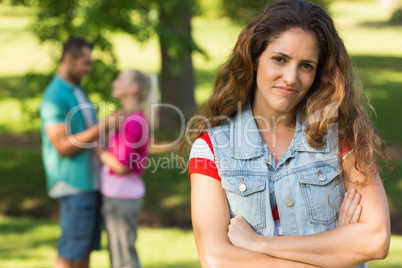 Angry woman with man and girlfriend in background at park