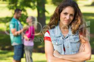 Angry woman with man and girlfriend in background at park