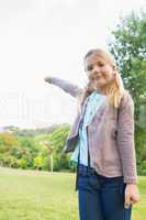Cute smiling young girl standing at park