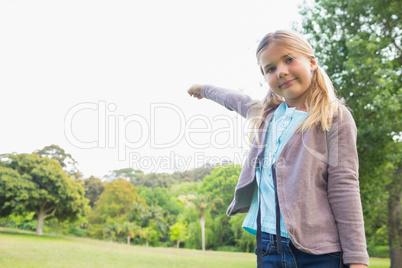 Cute smiling young girl standing at park