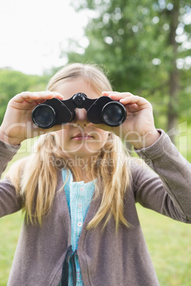 Girl looking through binoculars at park