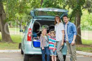 Family of four by car trunk while on picnic