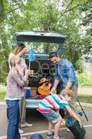 Family unloading car trunk while on picnic