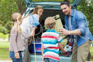 Family unloading car trunk while on picnic