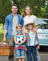 Happy family of four with picnic basket