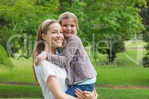 Mother carrying daughter at park