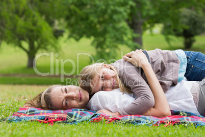 Relaxed mother and daughter lying at park