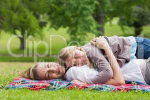 Relaxed mother and daughter lying at park