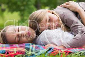 Relaxed mother and daughter lying at park