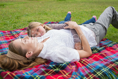 Relaxed mother and daughter lying at park