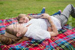 Relaxed mother and daughter lying at park