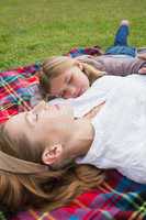 Relaxed mother and daughter lying at park