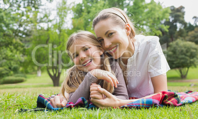 Happy mother with daughter lying at park