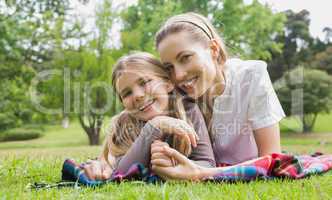Happy mother with daughter lying at park