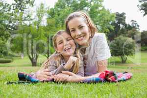 Happy mother with daughter lying at park