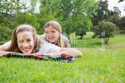 Happy mother with daughter lying at park