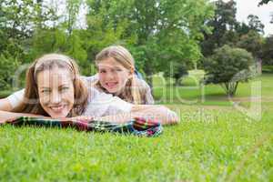 Happy mother with daughter lying at park