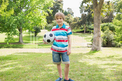 Portrait of a smiling boy with ball at park