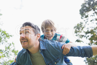 Father carrying cheerful boy on back