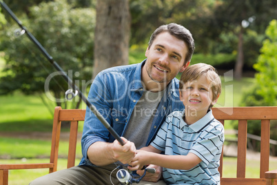 Father and son fishing on park bench