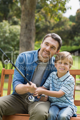 Father and son fishing on park bench