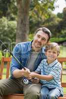 Father and son fishing on park bench