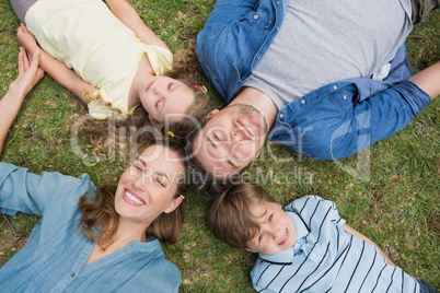 Happy parents and kids lying at park