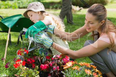 Mother and daughter watering plants at garden