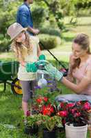 Mother with daughter watering plants